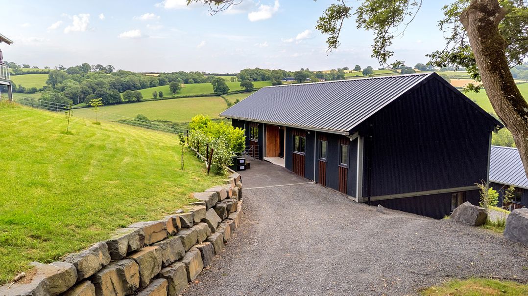 A house with a driveway and grass at Bwncath in Garthmyl