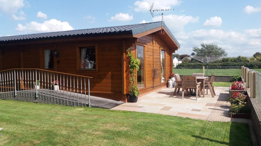 A log cabin with a patio and seating area at Chestnut Lodge in Pilling