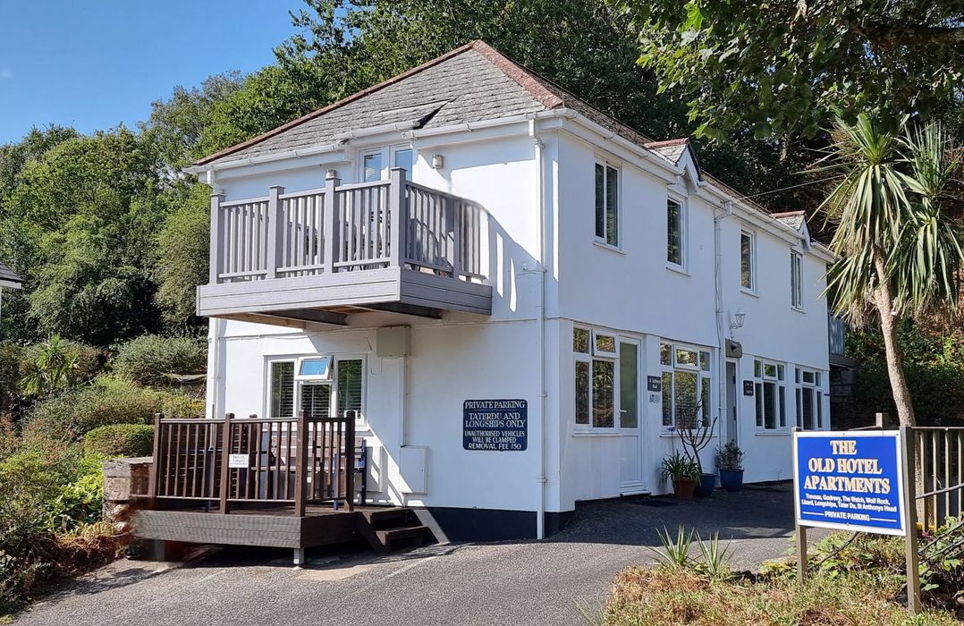 An exterior view of the Old Hotel Apartments with a balcony and plants at Tater-Du in Porthcurno near Land’s End