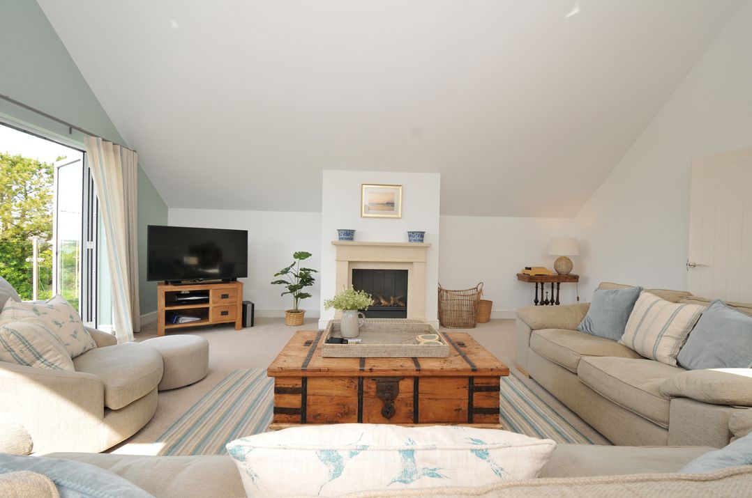A living room with a coffee table and television at Farlands in Daymer Bay