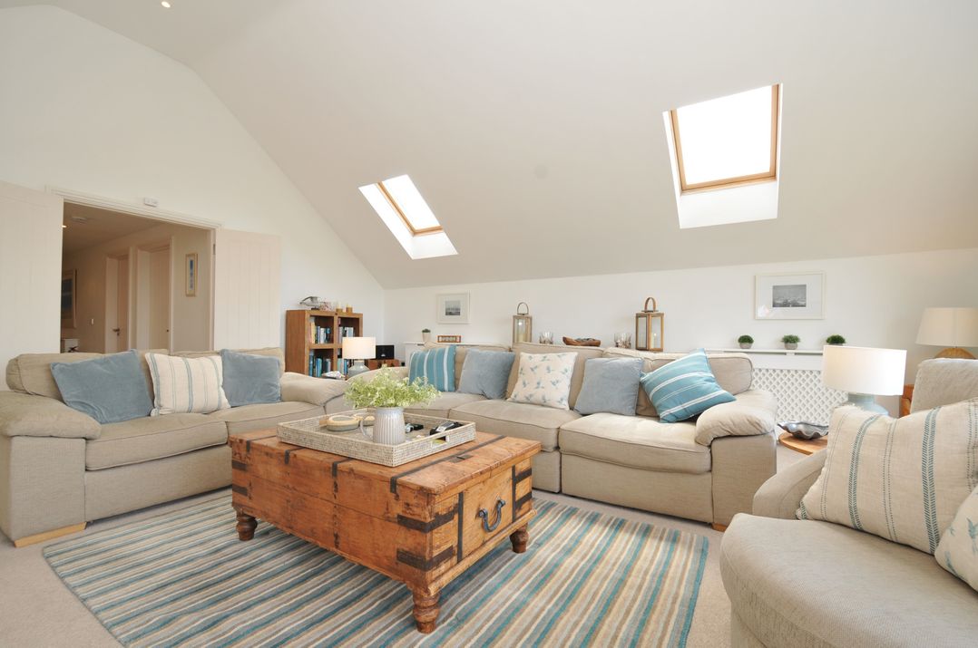 A living room with a coffee table and bookshelves at Farlands Daymer Bay