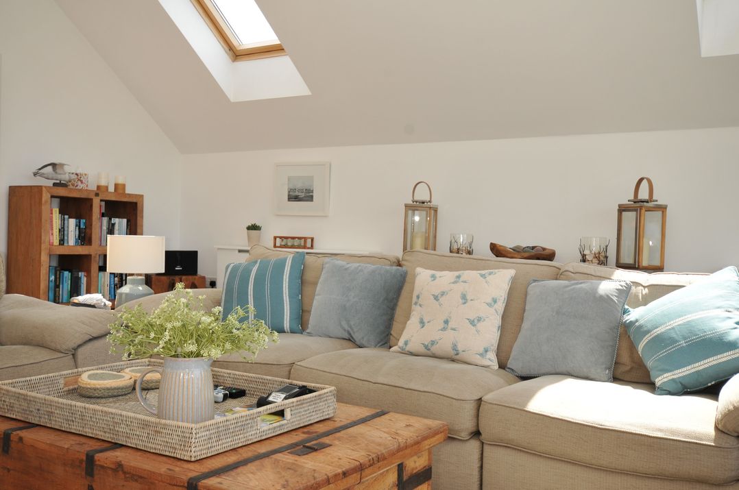 A living room with a couch and coffee table at Farlands in Daymer Bay