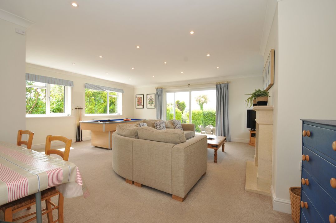 A living room with a sofa and pool table at Farlands in Daymer Bay