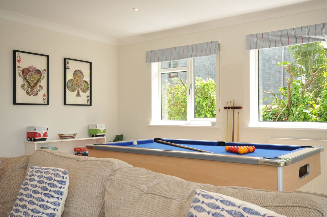 A snug room featuring a pool table and shelves at Farlands in Daymer Bay