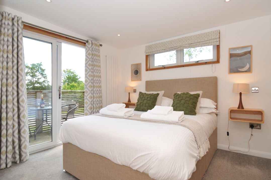 A bedroom with a bed and bedside tables at 12 Meadow Retreat in Dobwalls