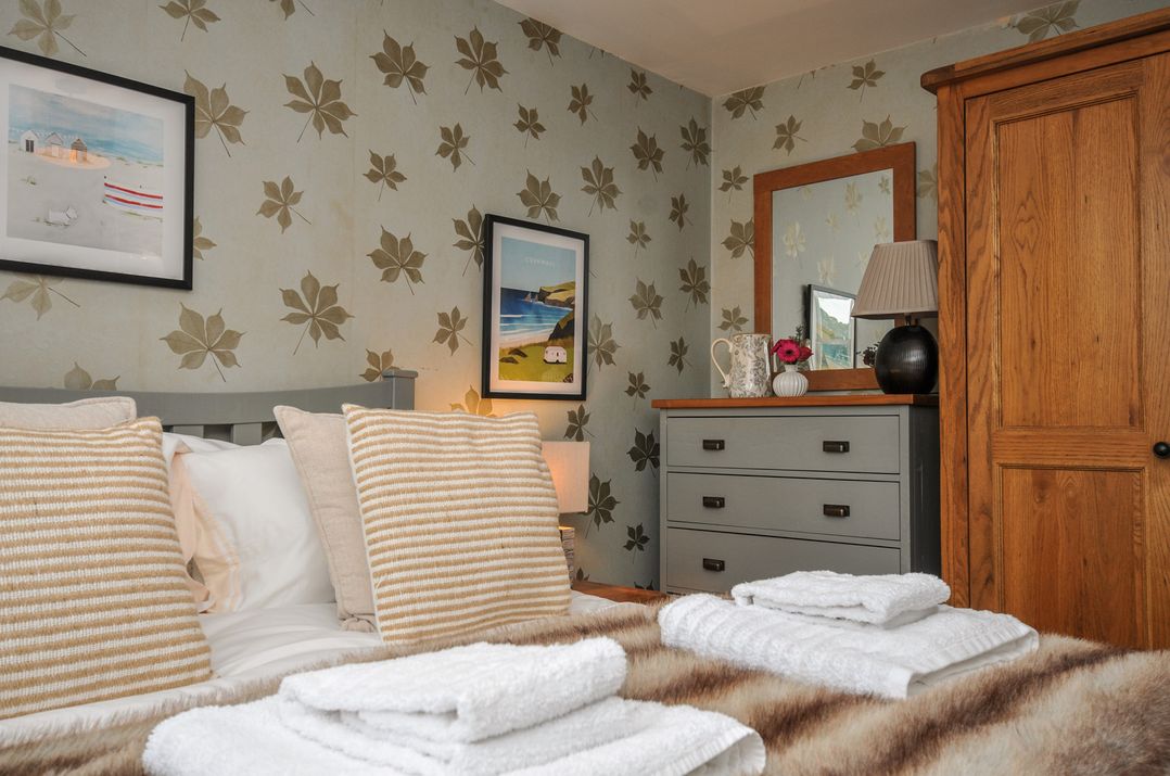 A bedroom with a bed and dressing table at The Hayloft in Lostwithiel