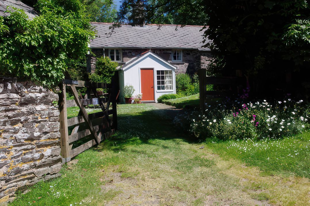 A garden with a path leading to a house at Whitefield Cottage in Brayford near North Molton