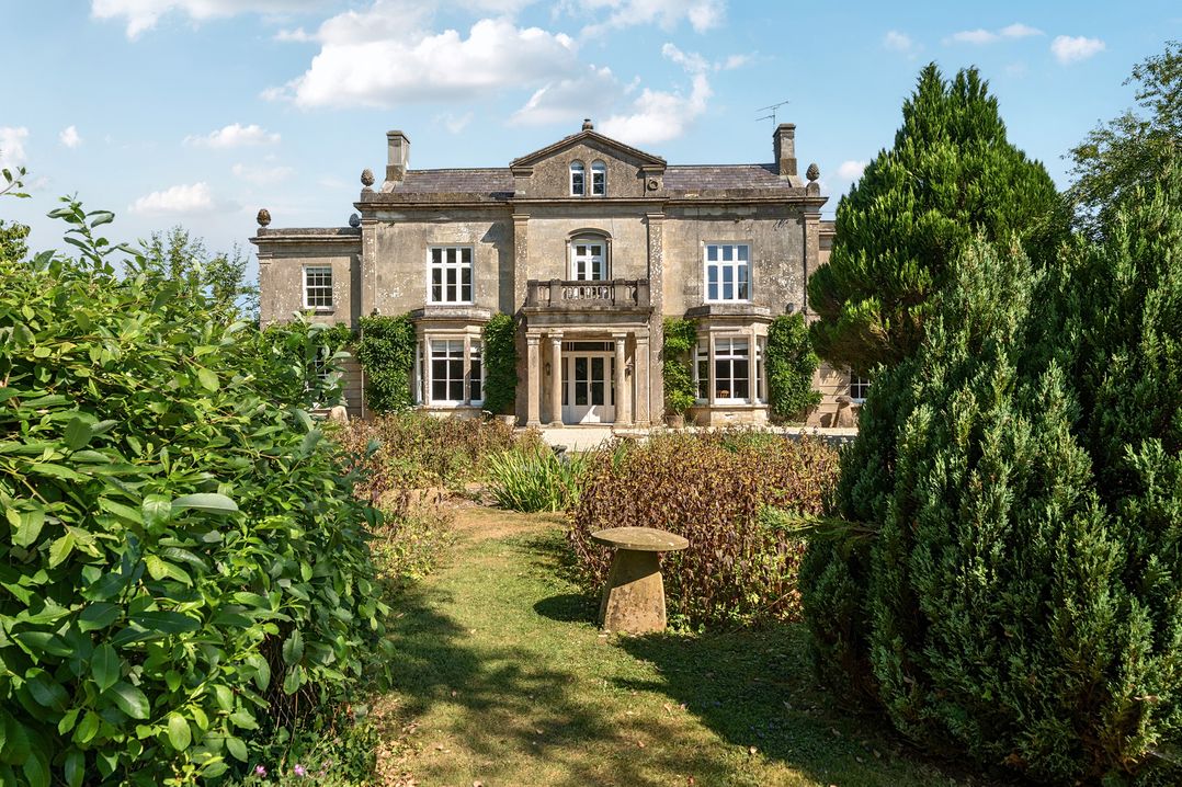 A house with a garden and trees at Milton Manor in Milton On Stour