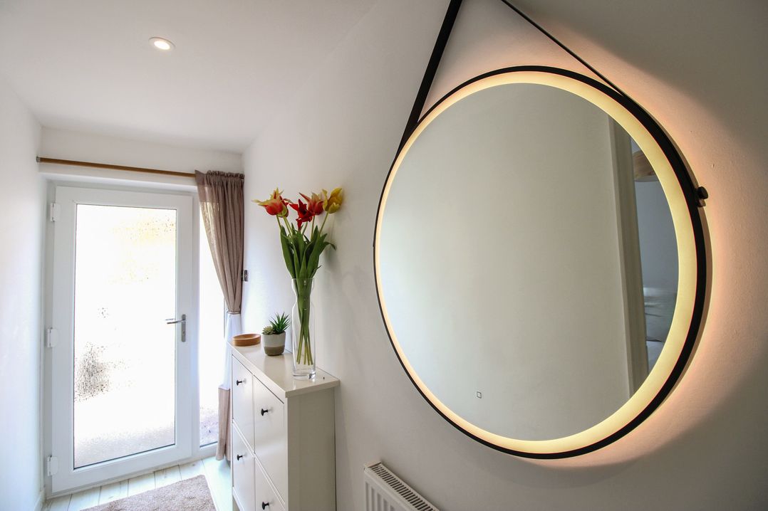 A hallway with a mirror and flower vase at Little Starboard in Kingsbridge