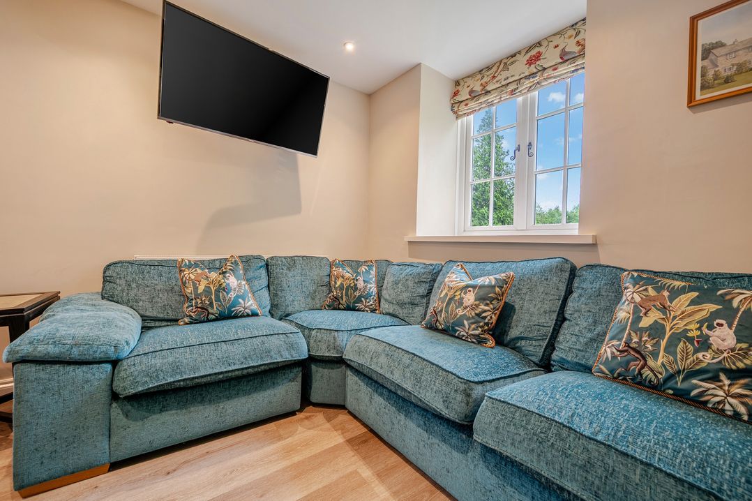 A living room with a sofa and television at Home Farmhouse at the Graythwaite Estate near Hawkshead