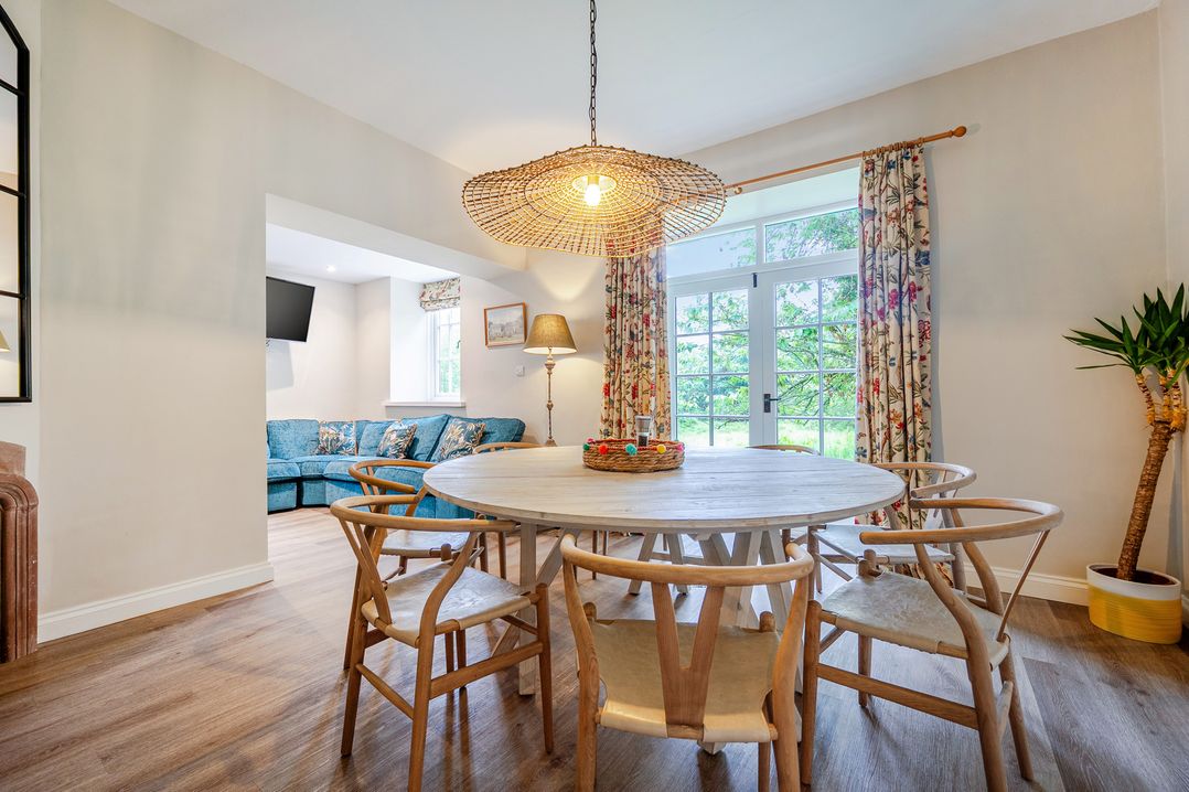 A dining area with a round table and chairs at Home Farmhouse at the Graythwaite Estate near Hawkshead