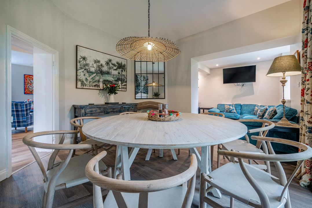 A dining room with a round table and chairs at Home Farmhouse at the Graythwaite Estate near Hawkshead