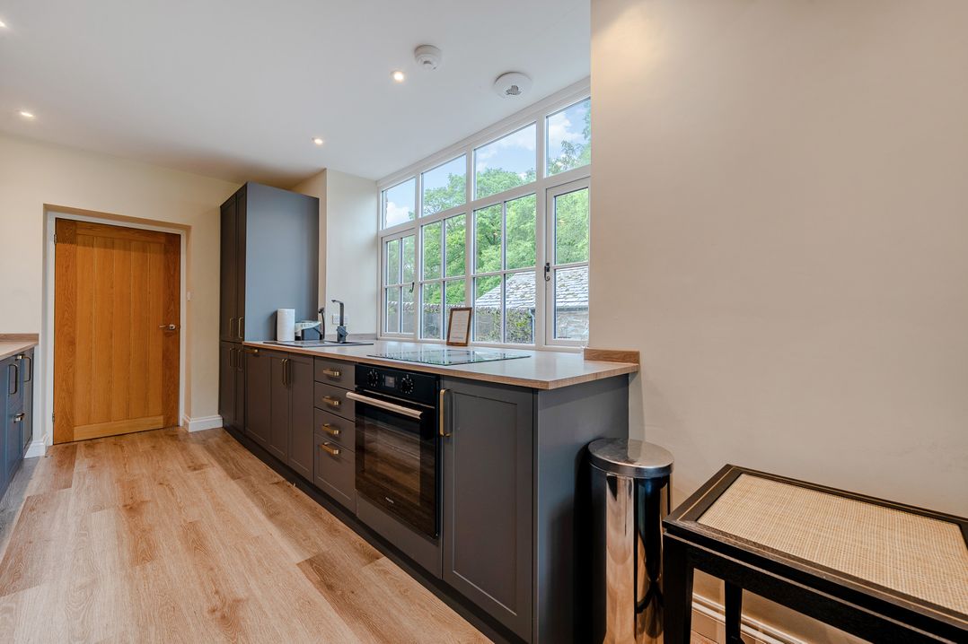 A kitchen with an oven and sink at Home Farmhouse at the Graythwaite Estate near Hawkshead