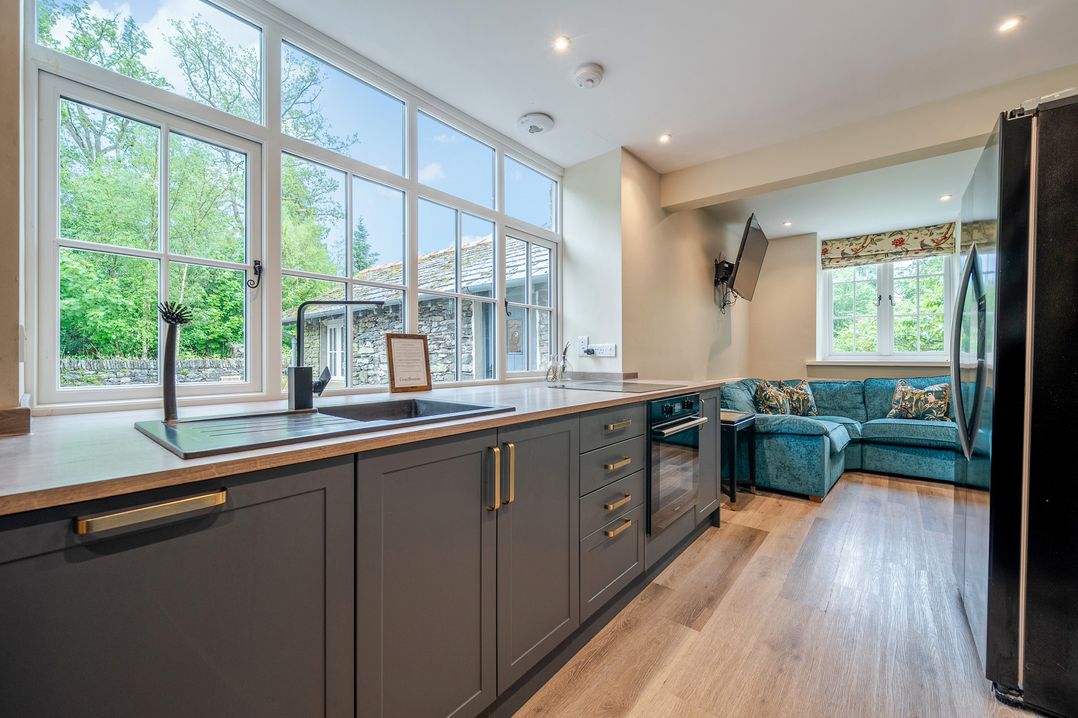 A kitchen with a sink and cooking area at Home Farmhouse at the Graythwaite Estate near Hawkshead