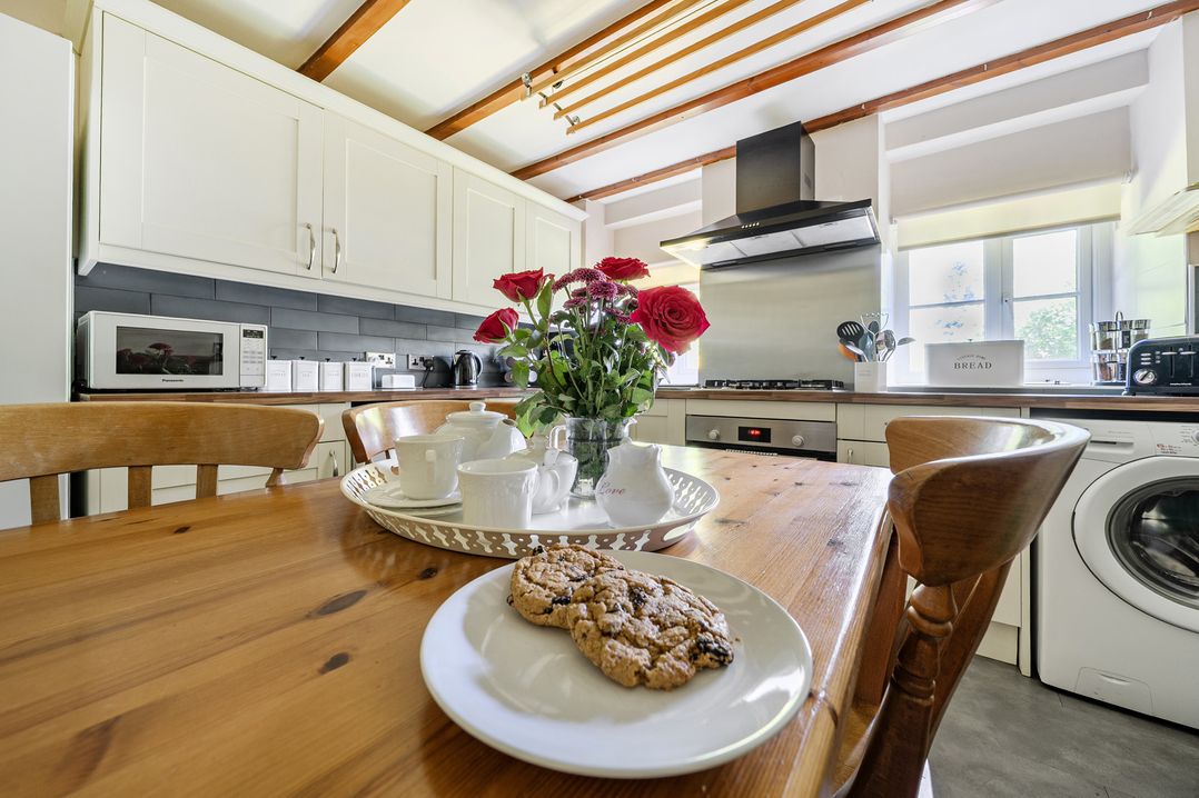 A kitchen with a table and chairs at Tyn Y Ffynnon in Betws-Y-Coed