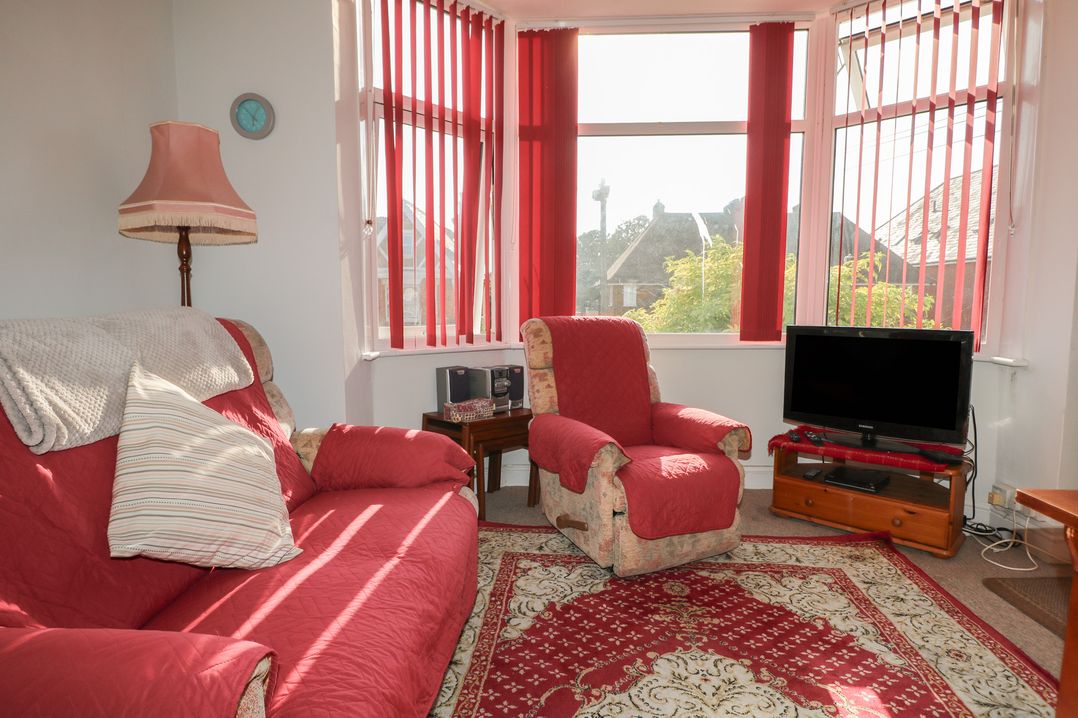 A living room with a sofa and an armchair at Sylvian in Bexhill-On-Sea