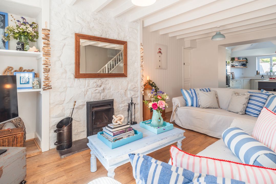 A living room with a coffee table and fireplace at Gerallt in Morfa Nefyn