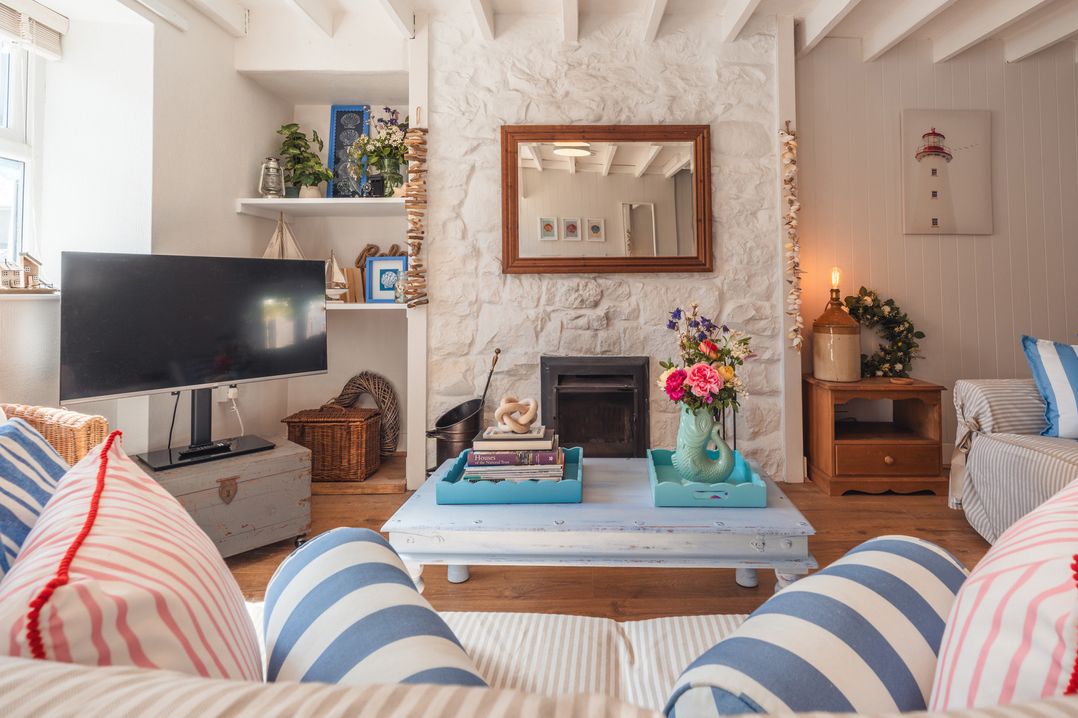 A living room with a coffee table and a television at Gerallt in Morfa Nefyn