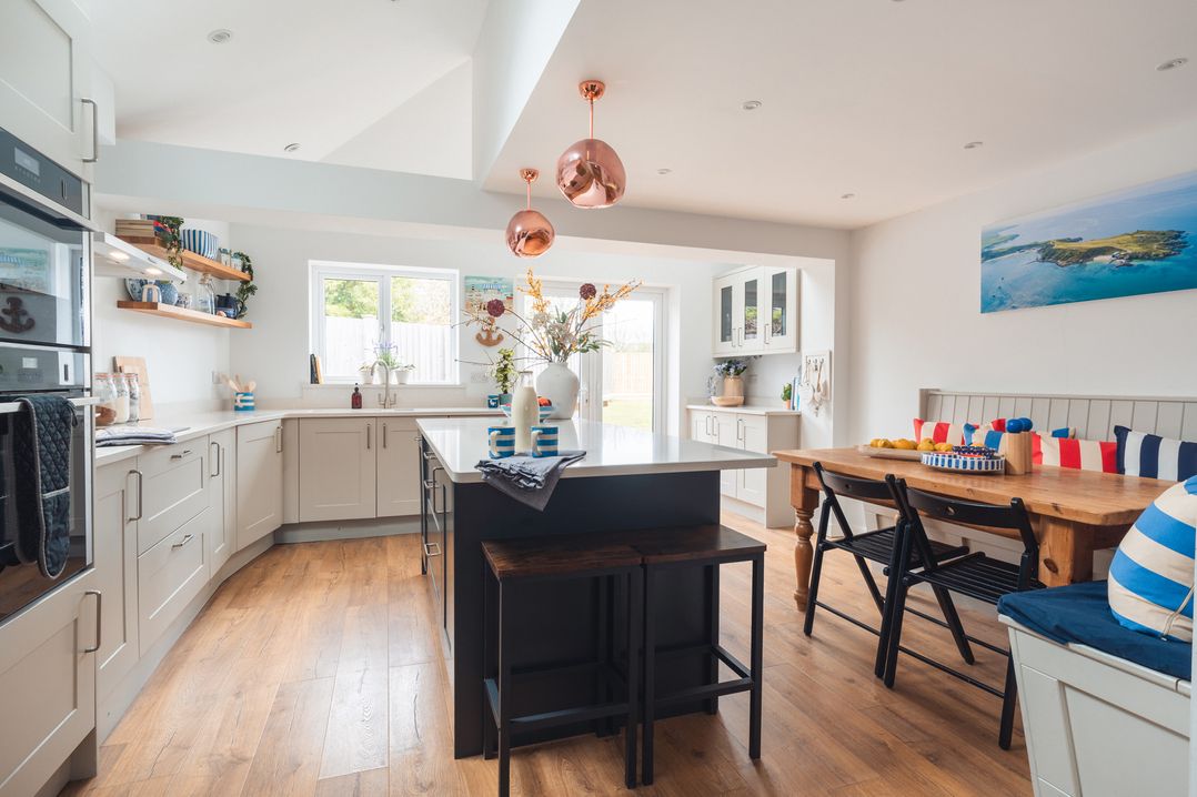 A kitchen with an island and table at Gerallt in Morfa Nefyn