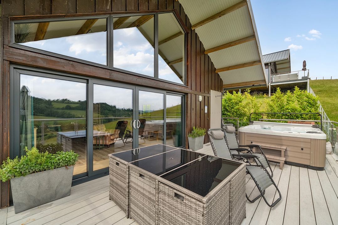 An outdoor area with hot tub and furniture at Bwncath in Garthmyl