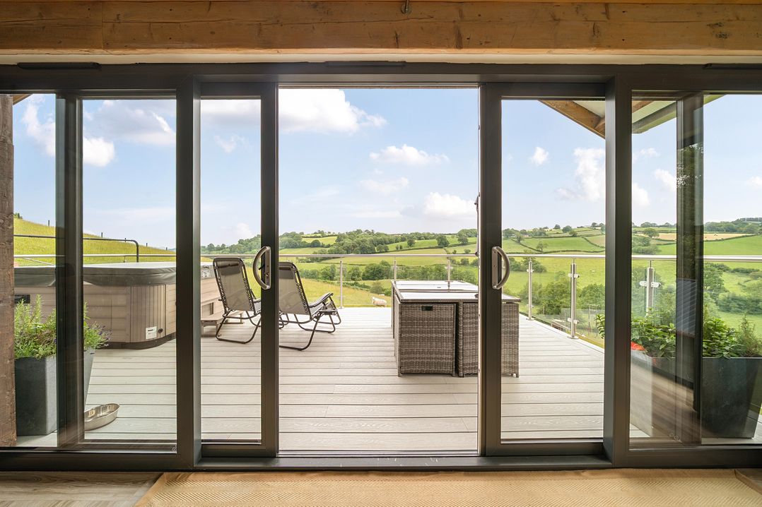 A balcony with outdoor furniture and a hot tub at Bwncath in Garthmyl