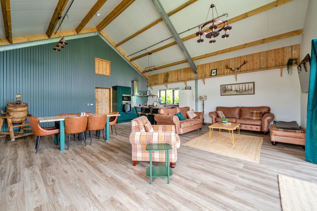 A living room with furniture and kitchen area at Bwncath Garthmyl