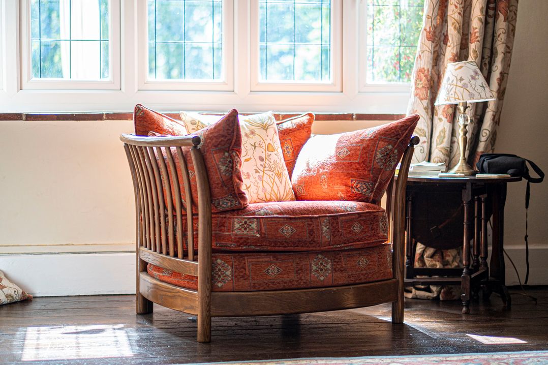 A chair with cushions near a window at Primrose Spinney Highwood near Ringwood
