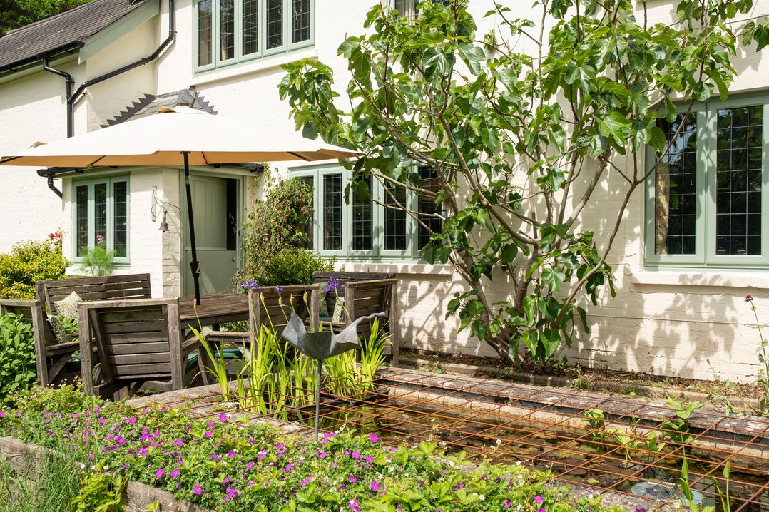 A garden with seating area and water feature at Primrose Spinney Highwood near Ringwood