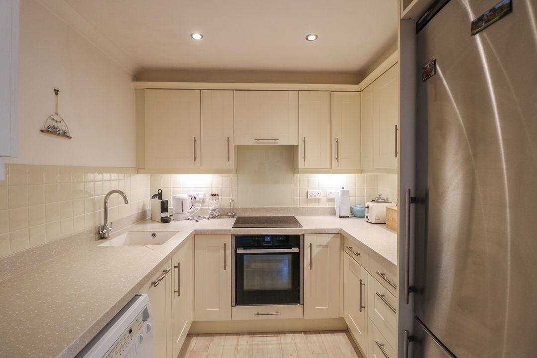 A kitchen with cupboards and appliances at November Cottage in Dittisham