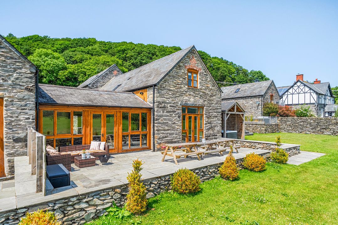 An outdoor space with a house and patio furniture at The Barn in Corwen