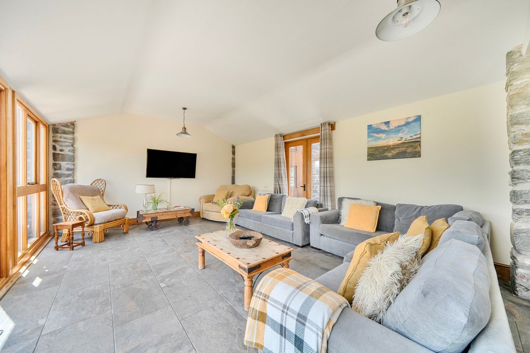 A living room with a sofa and coffee table at The Barn in Corwen