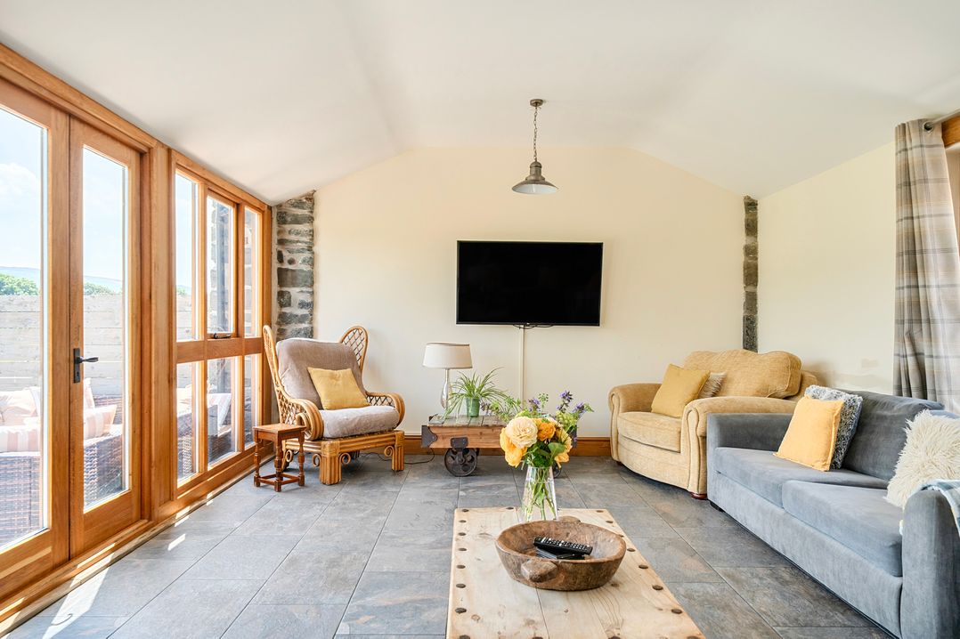 A snug with two sofas and a television at The Barn in Corwen