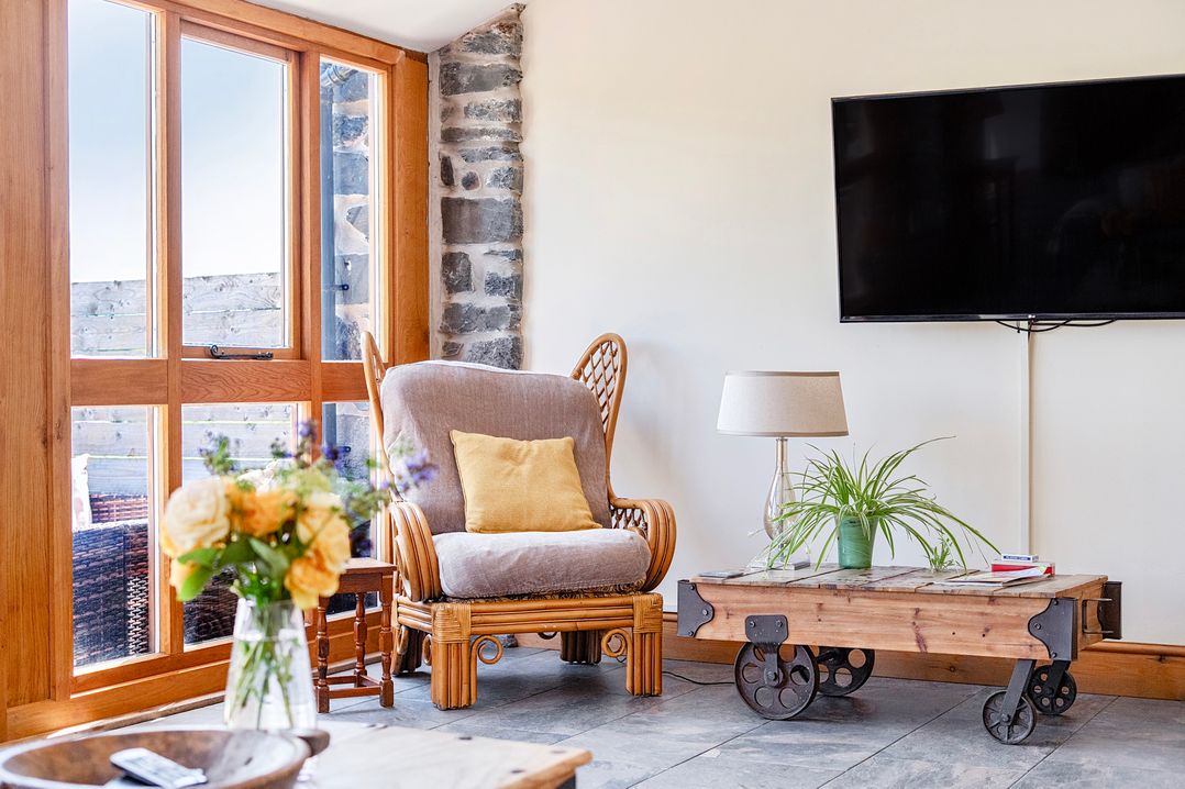 A living room with an armchair and a coffee table at The Barn in Corwen