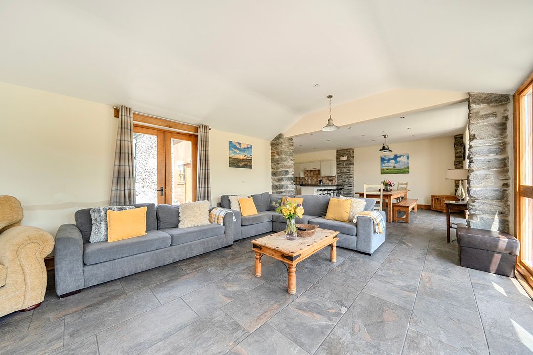 A living room with a sofa and table at The Barn in Corwen