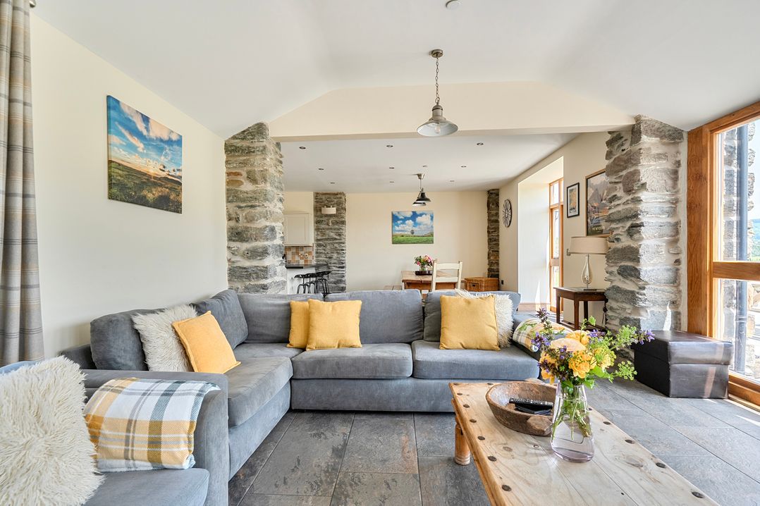 A living room with a sofa and coffee table at The Barn in Corwen