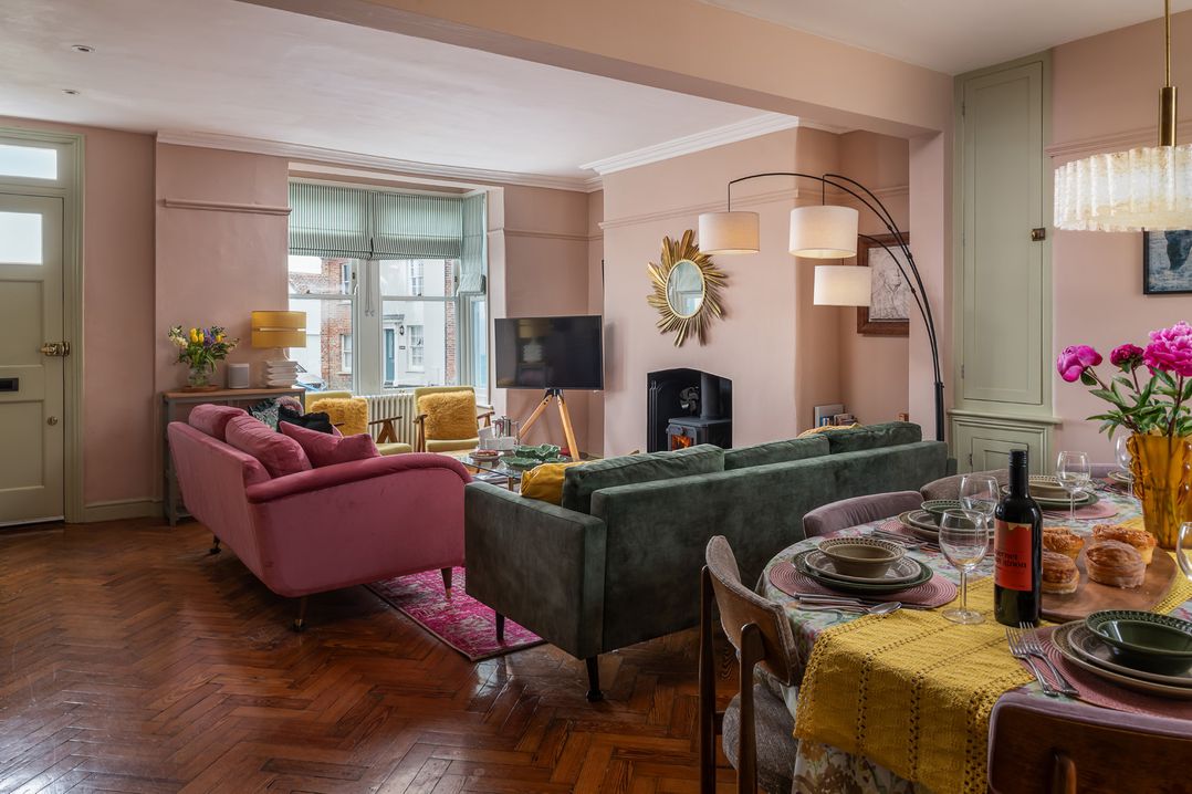 A living room with a sofa and dining area at Astondene, East Cliff Southwold