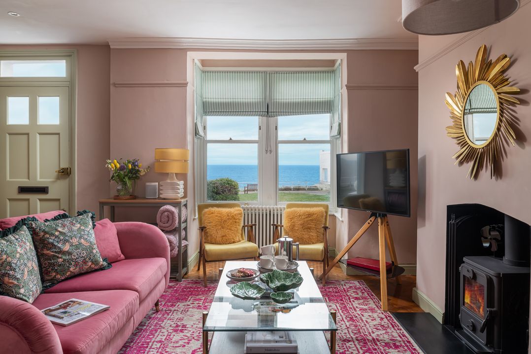 A living room with a sofa, TV and coffee table at Astondene, East Cliff, Southwold