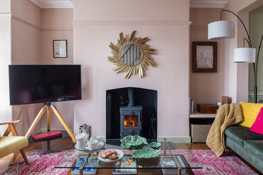 A living room with a fireplace and television at Astondene, East Cliff, Southwold