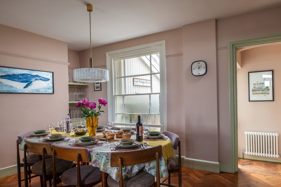A dining room with a table set for a meal at Astondene, East Cliff, Southwold