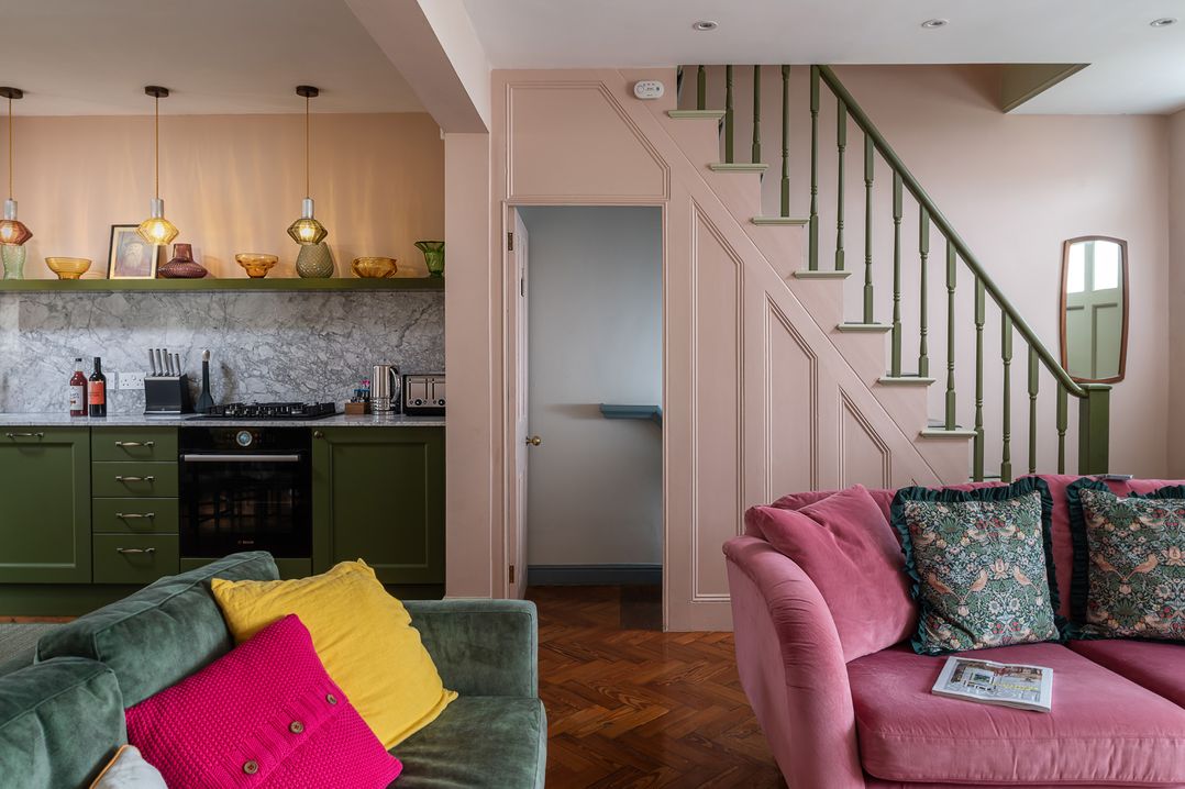 A living room with a kitchen area and staircase at Astondene, East Cliff, Southwold