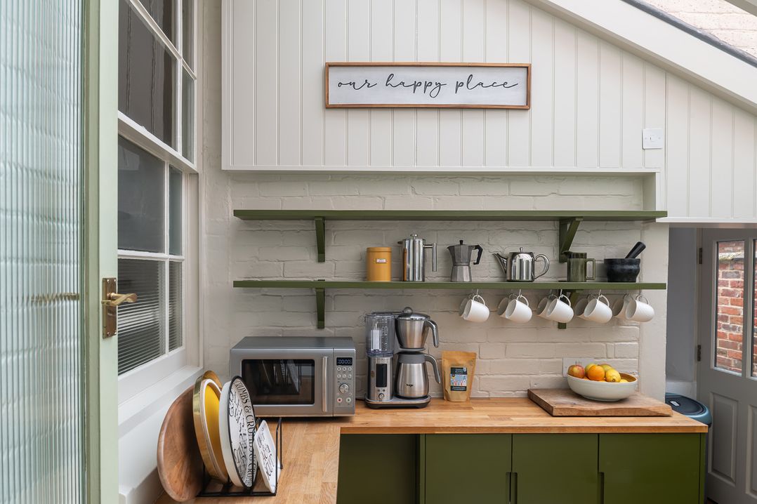 A kitchen with appliances and shelves at Astondene, East Cliff, Southwold