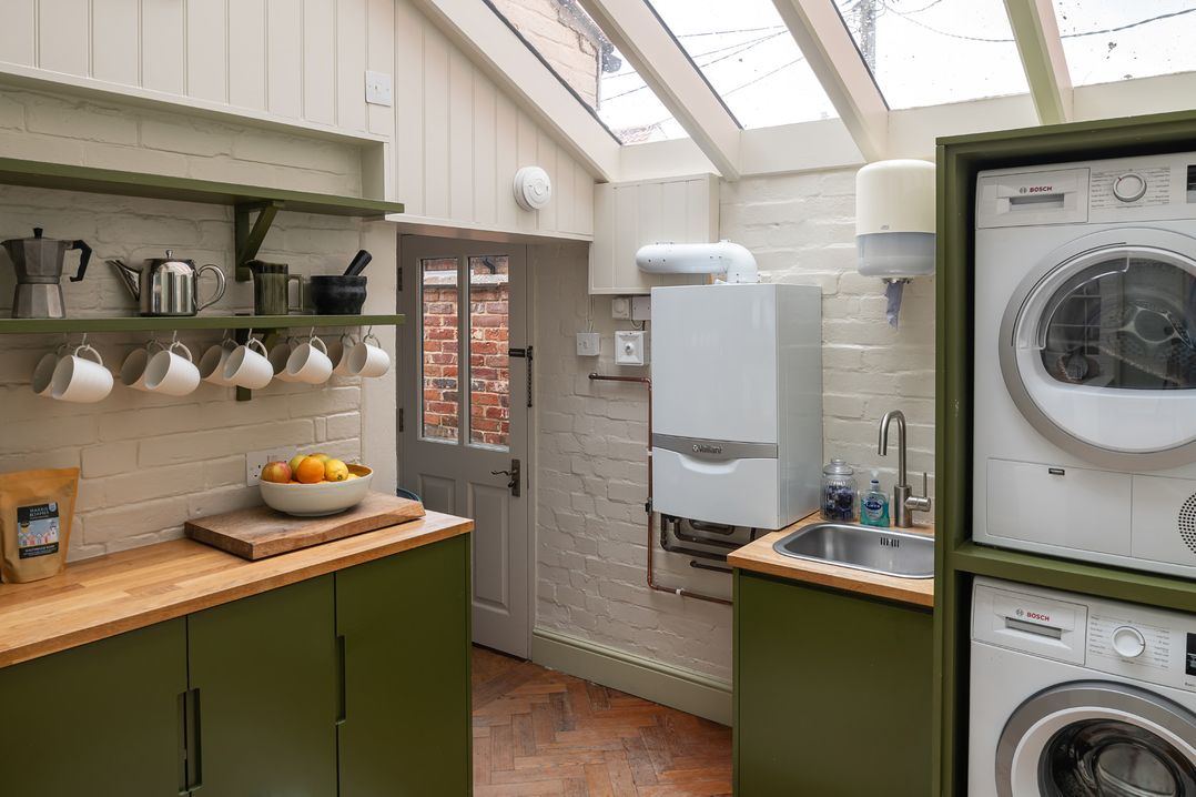 A kitchen with a sink and washing machine at Astondene, East Cliff, Southwold