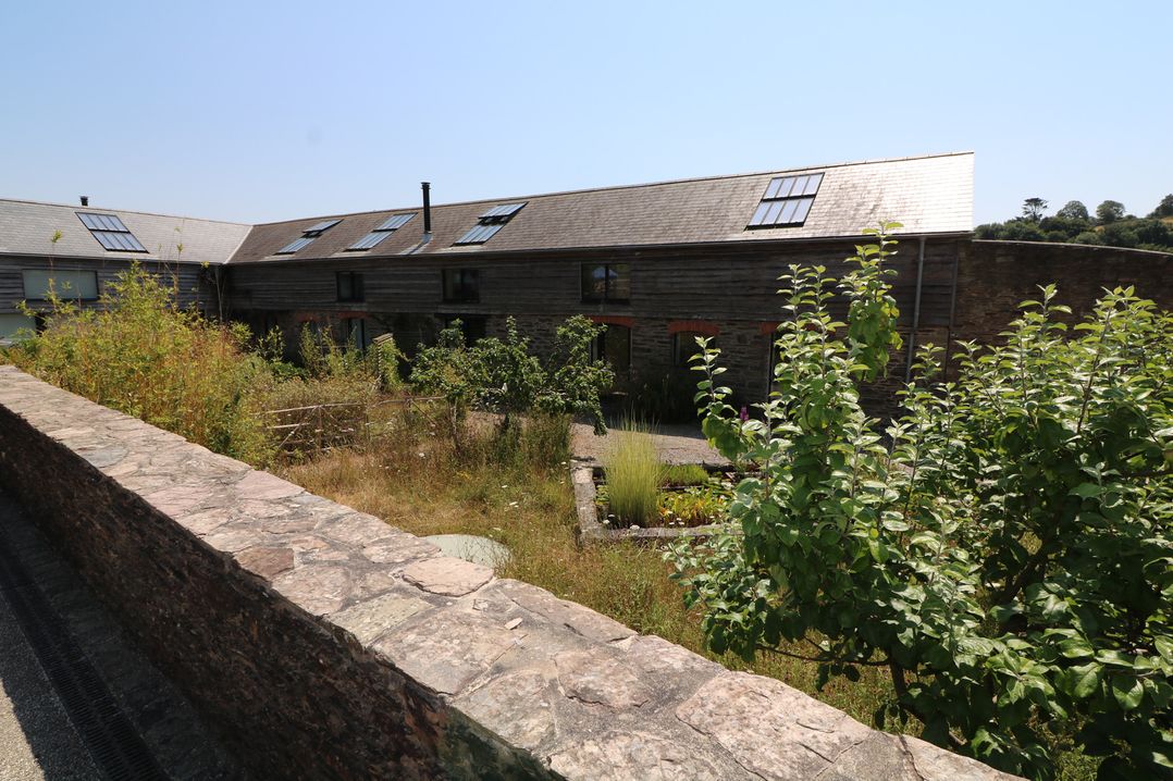 An outdoor area with a building and garden at The Milking Shed in Bantham