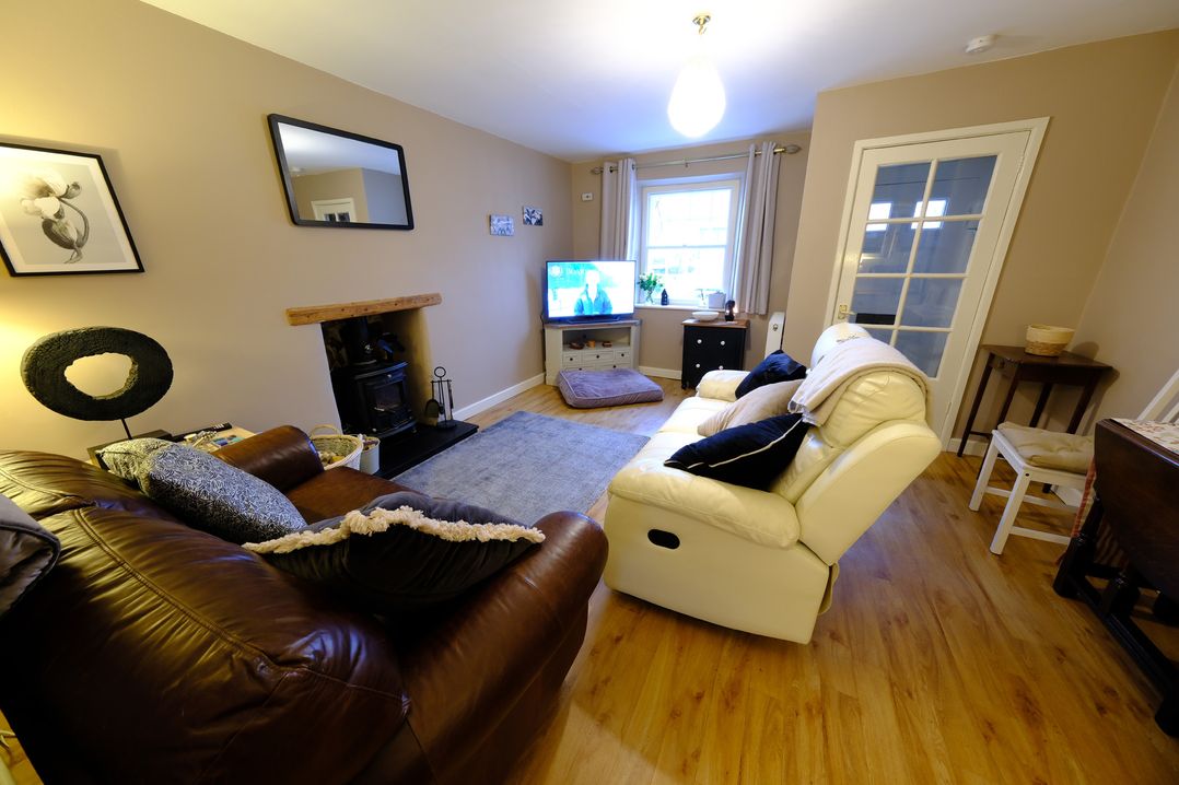 A living room with a sofa and television at Rose Cottage in Hartington