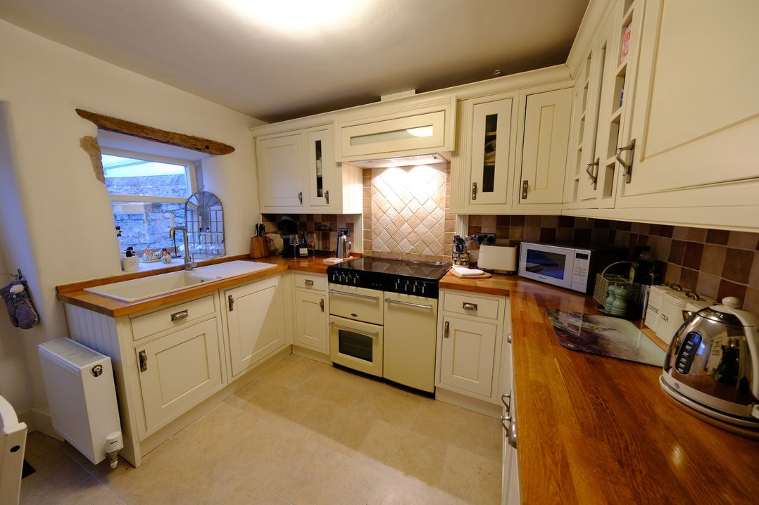 A kitchen with cabinets and appliances at Rose Cottage in Hartington