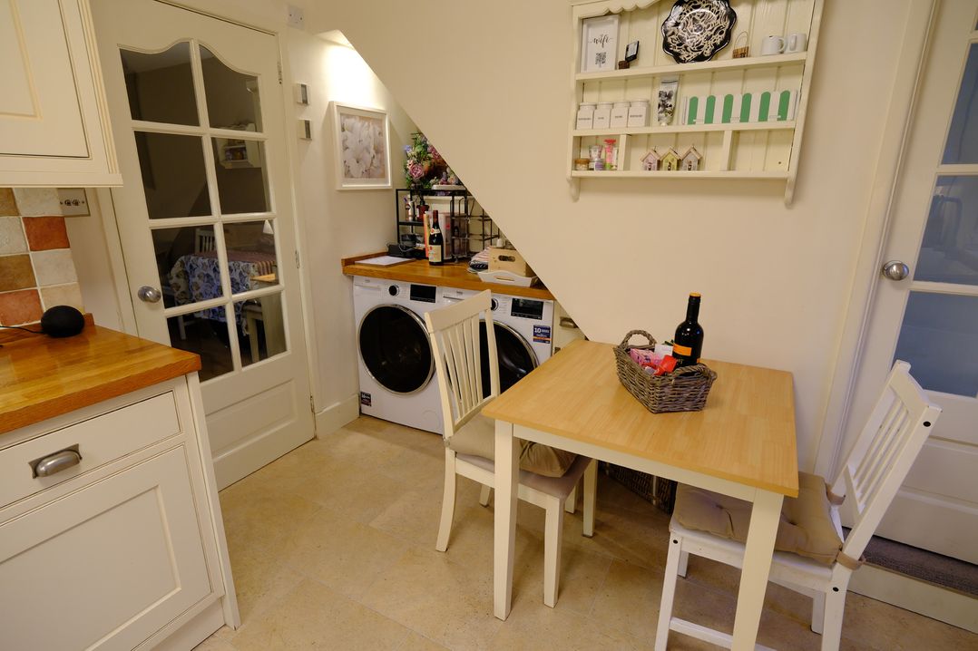 A kitchen with a table and washing machine at Rose Cottage Hartington