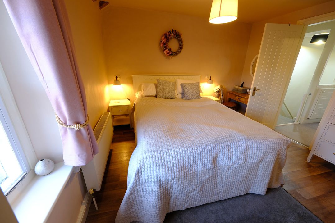 A bedroom with a bed and nightstand at Rose Cottage in Hartington