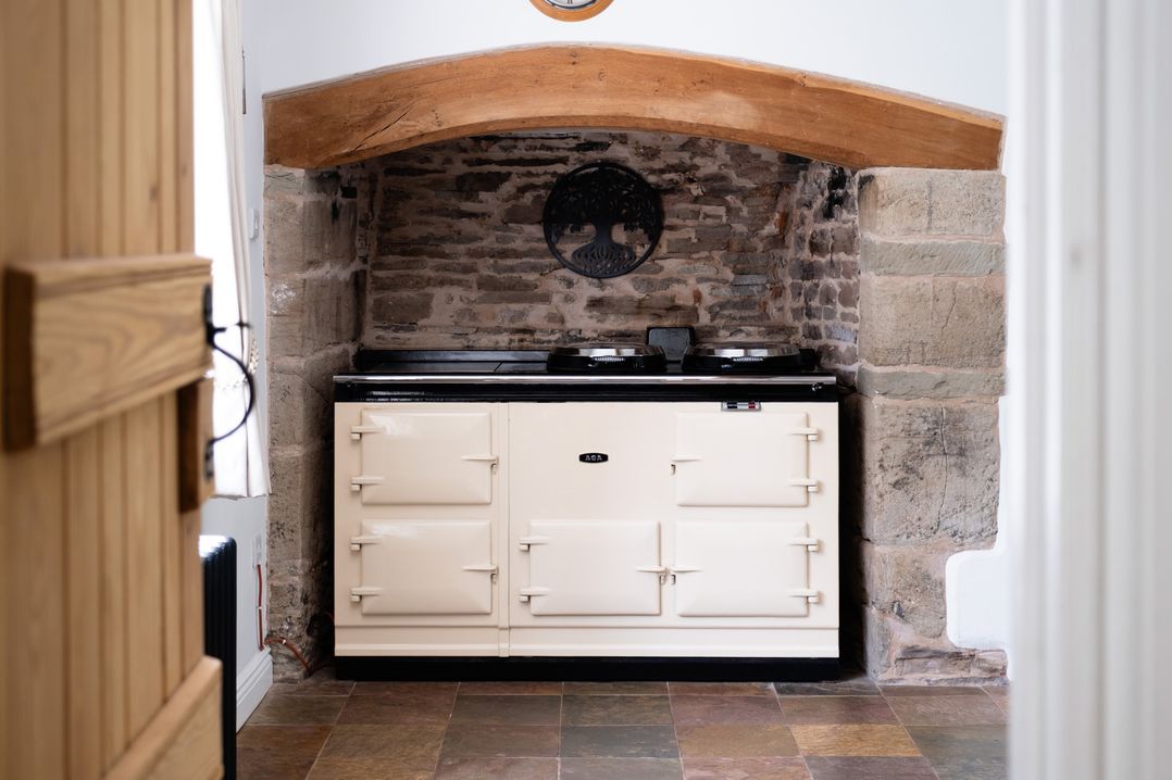 A kitchen with an oven and brick wall at Henhouse Farm in Bodenham