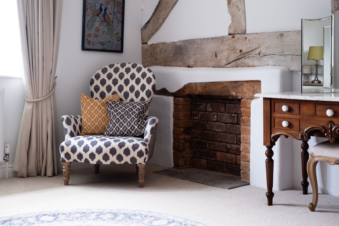 A living room with an armchair and fireplace at Henhouse Farm in Bodenham