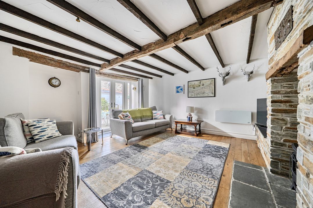A living room with a sofa and armchair at Mews Cottage in Tintagel